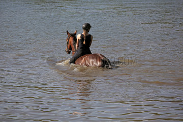 Oberoderwitz  Maedchen reitet mit ihrem Pferd durch einen See