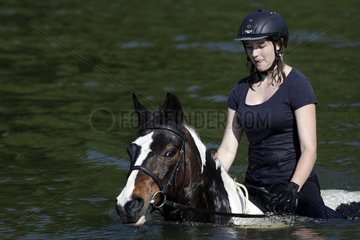 Oberoderwitz  Maedchen reitet mit ihrem Pferd durch einen See