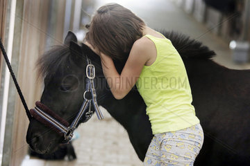 Oberoderwitz  kleines Maedchen kuschelt traurig mit ihrem Pony