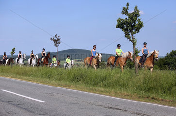 Oberoderwitz  Frauen und junge Maedchen reiten neben einer Landstrasse