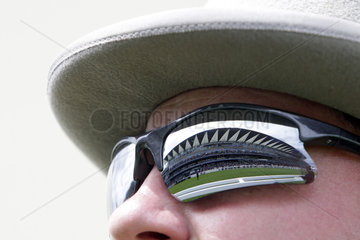Royal Ascot  the grandstand mirrores in the sunglasses of a man