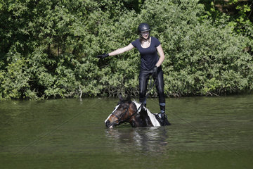 Oberoderwitz  Maedchen turnt auf ihrem Pferd in einem See