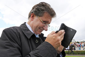 Hamburg  Besitzer Christian Sundermann schaut auf sein Smartphone