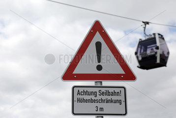 Berlin  Deutschland  Schild - Achtung Seilbahn - vor einer Seilbahngondel