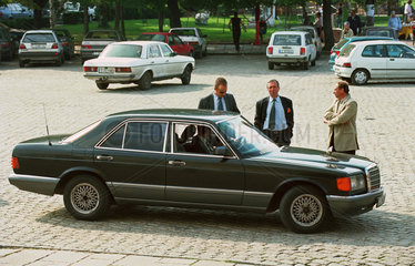 Fahrer und Bodyguards einer Persoenlichkeit warten bei deren Limousine  Sofia
