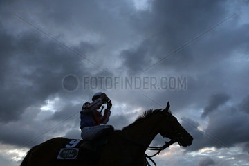 Hamburg  Silhouette  Pferd und Jockey vor dunklen Gewitterwolken