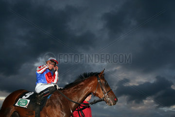 Hamburg  Pferd und Jockey vor dunklen Gewitterwolken