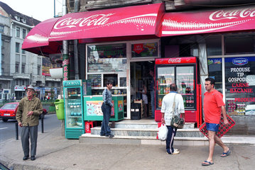 Strassenszene vor einem Lebensmittelladen mit Coca-Cola-Werbung in Bukarest