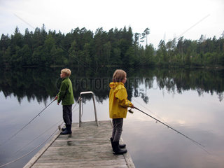 Karlskrona  Schweden  zwei Kinder stehen auf einem Steg und angeln