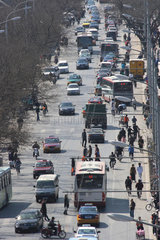 Peking  Blick in eine Strasse mit Autos  Bussen  Fussgaengern
