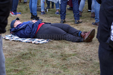 Hoppegarten  Deutschland  Frau schlaeft inmitten einer Menschenmenge auf dem Boden