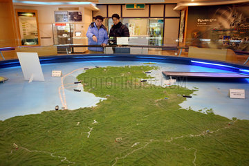 Odusan  Touristen schauen sich ein Modell von Nord und Suedkorea im Odusan Unification Observatory an