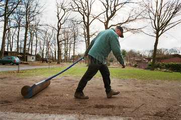 Mann walzt den Boden beim Rasen pflanzen  Norddeutschland