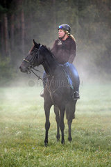 Hoppegarten  Pferd und Reiterin am Morgen bei einem Ausritt im Nebel. Lady Lilian mit Friederike Schloms