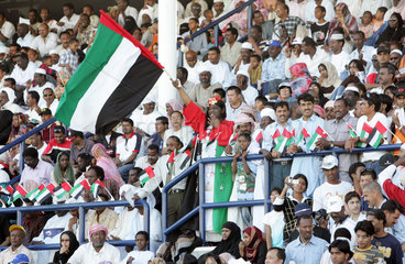 Dubai  Einheimische mit Nationalflaggen auf der Tribuene der Rennbahn Nad Al Sheba