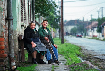 Ein aelteres Bauernpaar sitzt vor ihrem Haus  Rumaenien