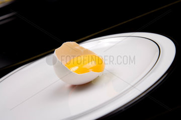 Berlin  Deutschland  geoeffnetes rohes Ei auf einem Teller