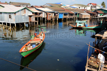 Koh Kong  Kambodscha  Longtailboot faehrt zwischen Pfahlbauten