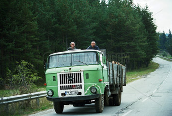 Zwei Maenner fahren per Anhalter auf einem Pritschenwagen  Bulgarien