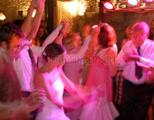 Eine Braut tanzt ausgelassen mit den Gaesten
