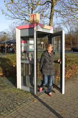Flensburg  Deutschland  eine Frau kommt aus einer eine Telefonzelle