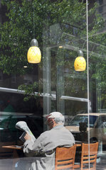 New York City  USA  alter Mann liest Zeitung in einem Cafe