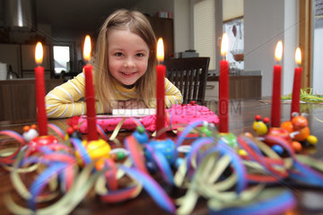 Handewitt  Deutschland  ein Maedchen mit Kerzen und Geschenken an seinem sechsten Geburtstag