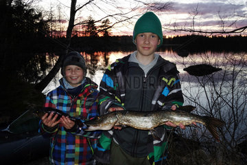 Lessebo  Schweden  Jungen zeigen stolz ihre selbst geangelten Fische am See Rottnen