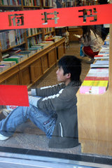 Peking  junger Chinese sitzt in einer Buchhandlung