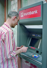 Tourist an einem Geldautomaten in Poznan  Polen