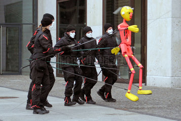 Berlin  Deutschland  maskierte Menschen bewegen eine Marionette