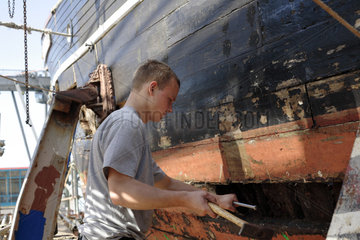 Lehrling bei der Restaurierung eines alten Schiffes in Stralsund