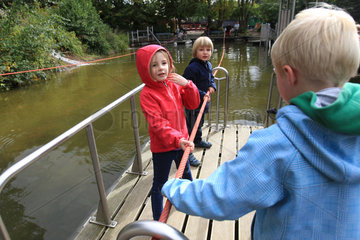 Tolk  Deutschland  Kinder auf einem Floss mit Zugseil im Freizeitpark Tolk-Schau