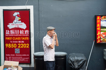Singapur  Republik Singapur  Mann telefoniert in Chinatown