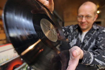 Flensburg  Deutschland  Plattenhaendler Andreas Thomsen mit einer Schallplatte aus Vinyl
