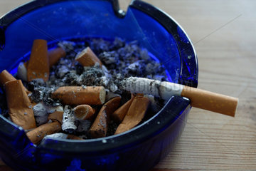 Eine Zigarette qualmt in einem Aschenbecher