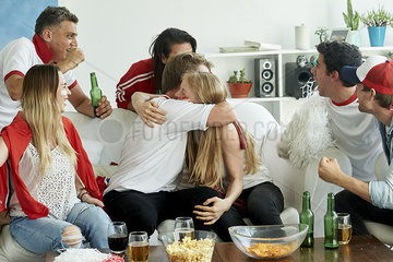 English soccer fans watching match together at home