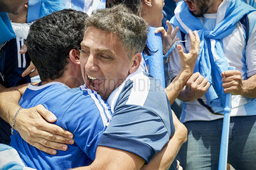Argentinian football fans embracing at football match