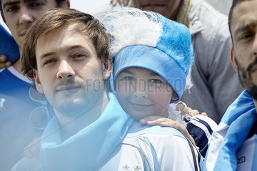 Father and son watching football match  portrait
