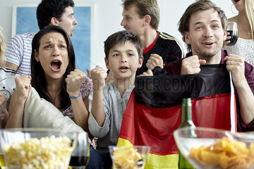 German football supporters watching match at home