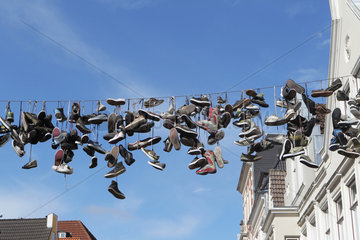 Flensburg  Deutschland  Schuhpaare an Drahtseilen ueber der Norderstrasse