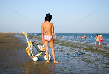 Spanien  Isla Canela  junge Frau mit ihrem Baby am Strand