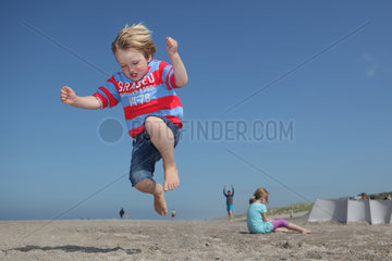 Hvide Sande  Daenemark  ein Junge macht am Strand einen Sprung