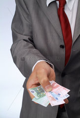 Hamburg  Deutschland  ein Mann haelt Miniaturgeldscheine in der Hand