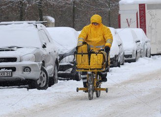 Berlin  Deutschland  ein Brieftraeger auf seinem Fahrrad im verschneiten Berlin