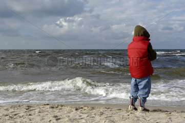 Ein kleiner Junge schaut aufs Meer