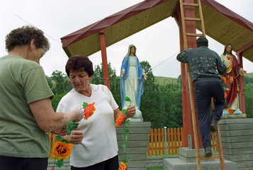Menschen beim Schmuecken eines Kreuzes  Polen