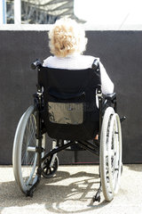 London  eine Frau im Rollstuhl vor einer Wand