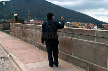 Heidelberg  Deutschland  fotografierender Tourist auf der Alten Neckarbruecke