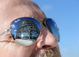 Berlin  Deutschland  Spiegelung der Reichstagskuppel in den Glaesern einer Sonnenbrille